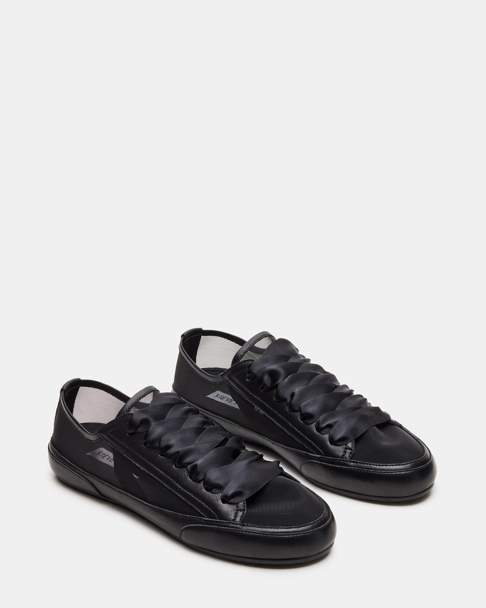 TREAD black leather sneakers paired with casual attire for a trendy look.