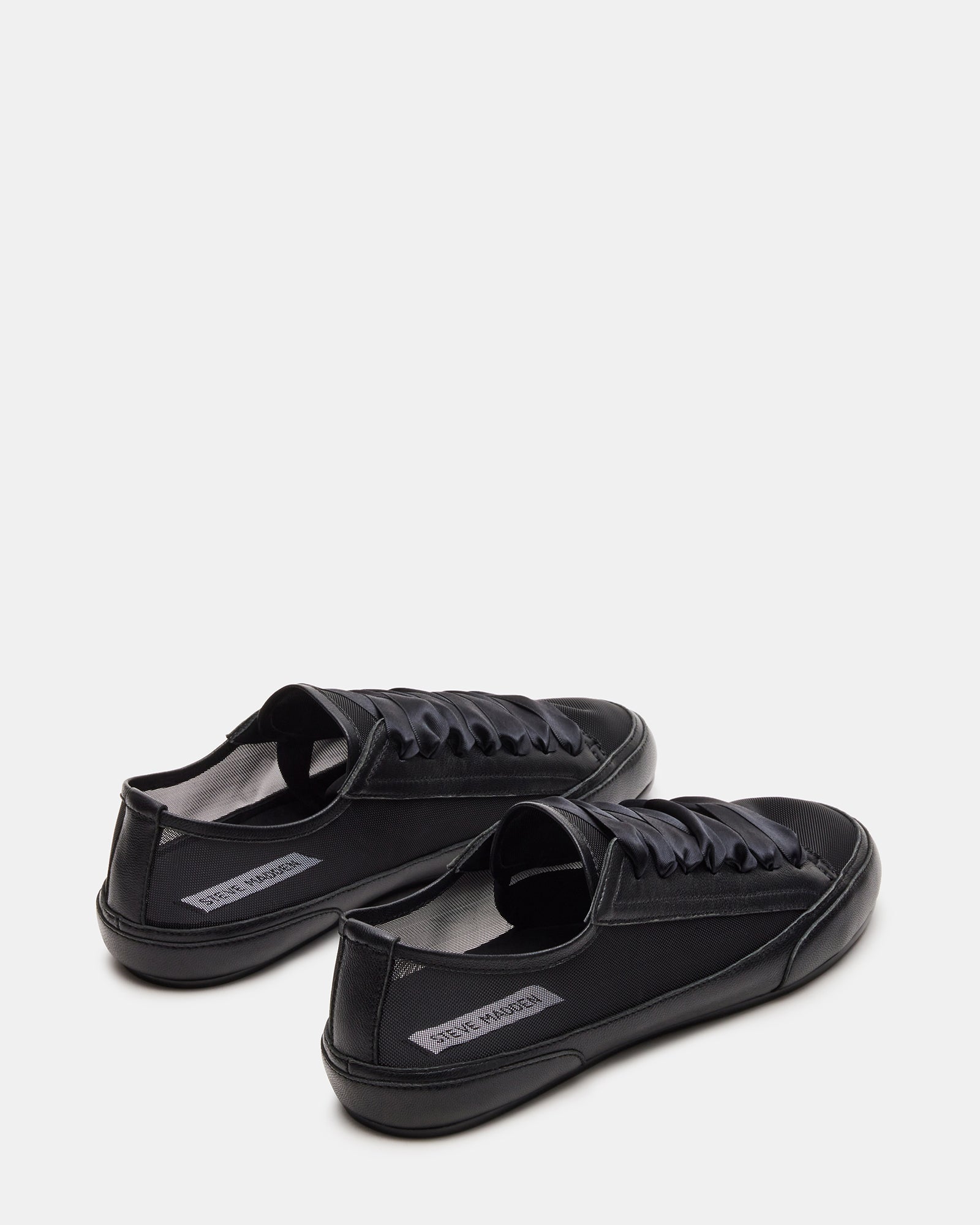 TREAD black leather sneakers paired with casual attire for a trendy look.