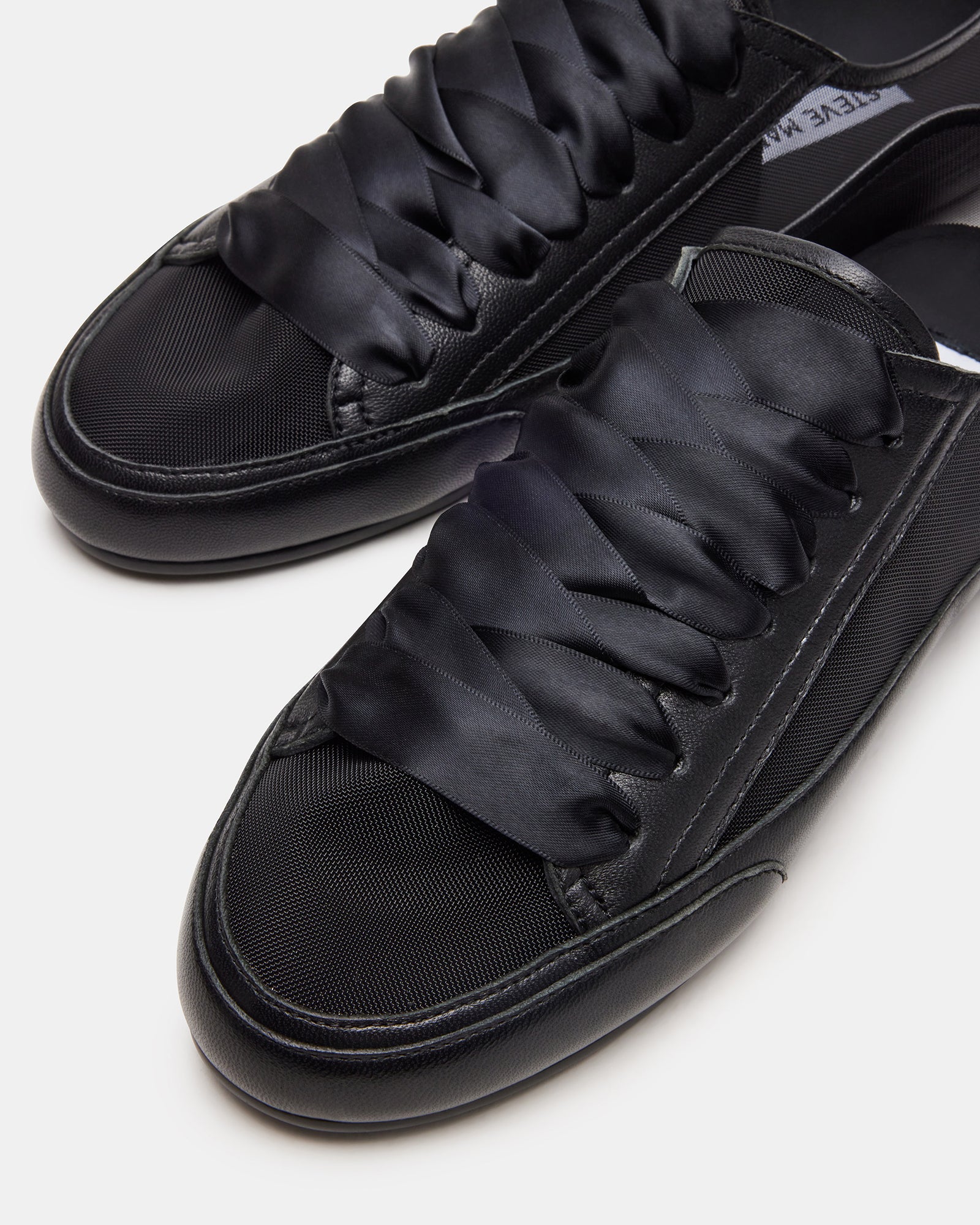 Top-down view of TREAD black leather lace-up sneakers showcasing their design.