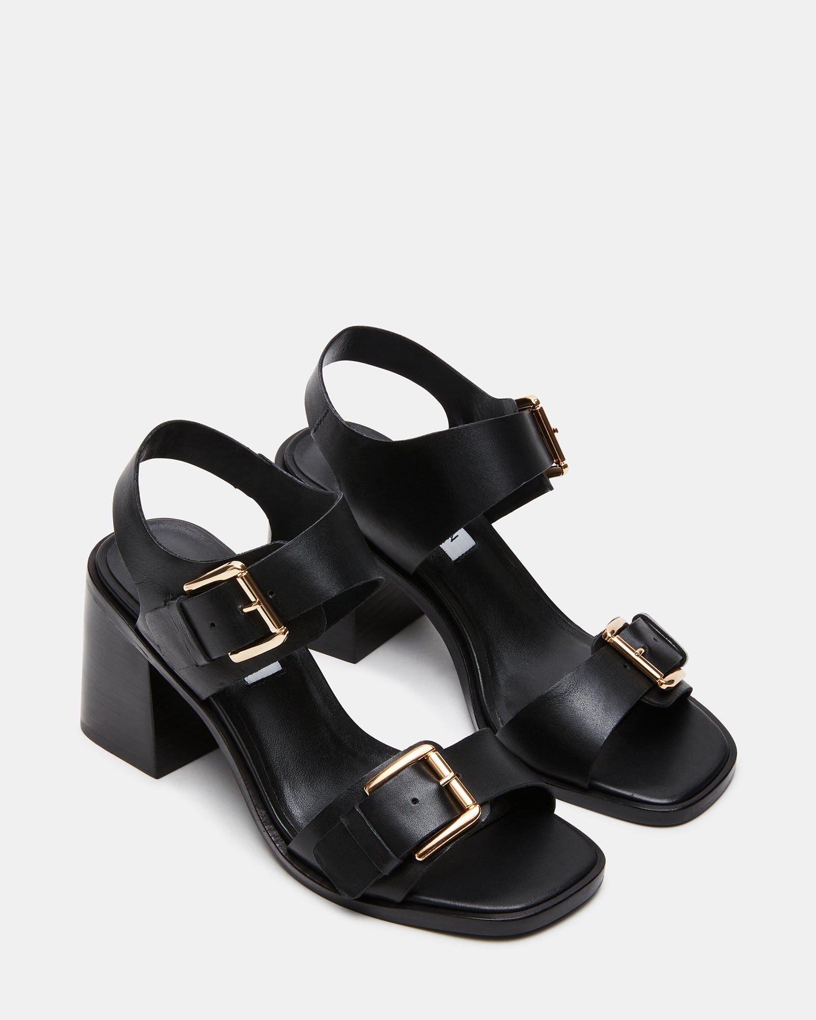 Close-up of buckle hardware on black leather sandals.