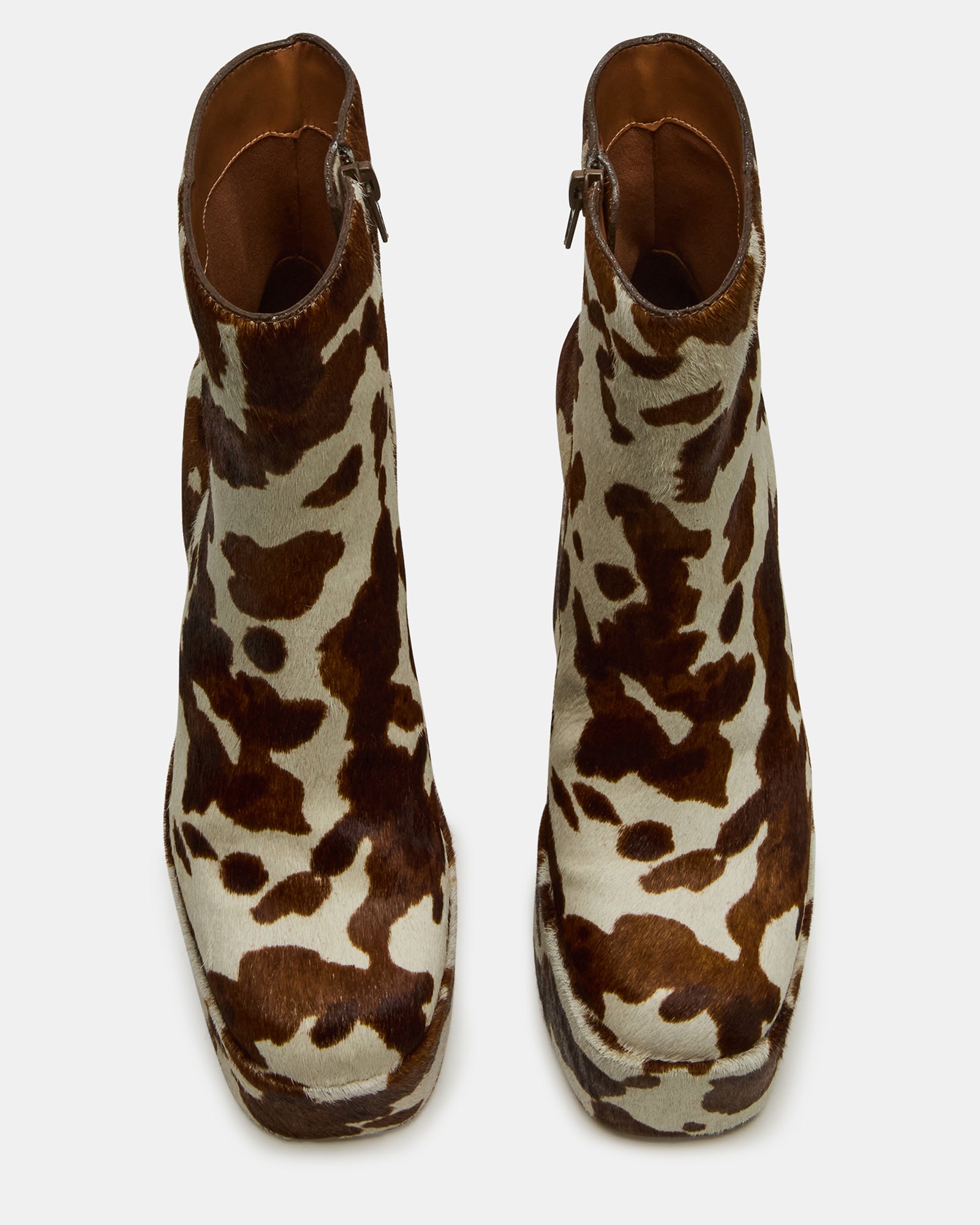 Side view of Trillion cow print platform ankle boot with chunky heel on urban street