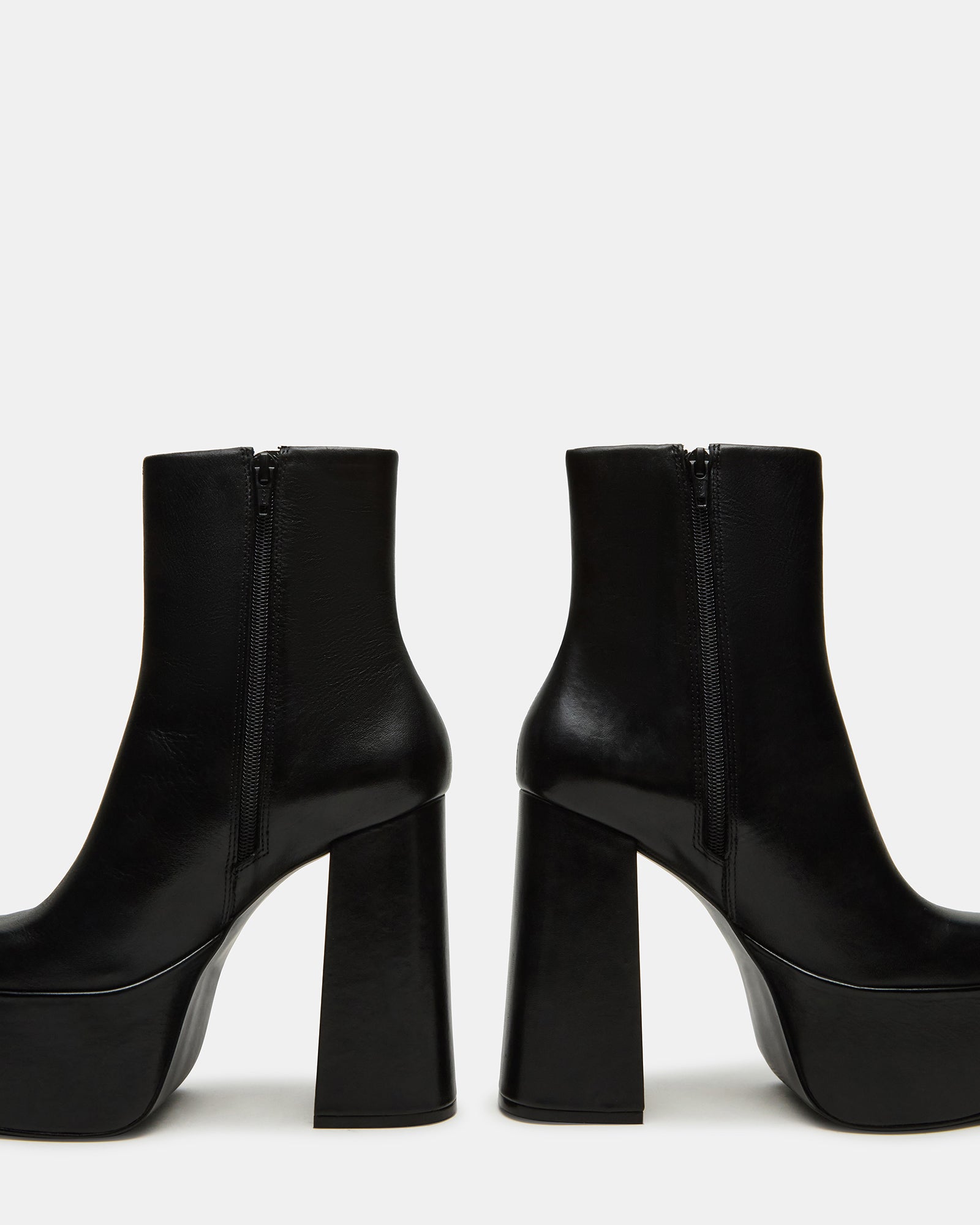 Full view of stylish black ankle boots paired with denim.