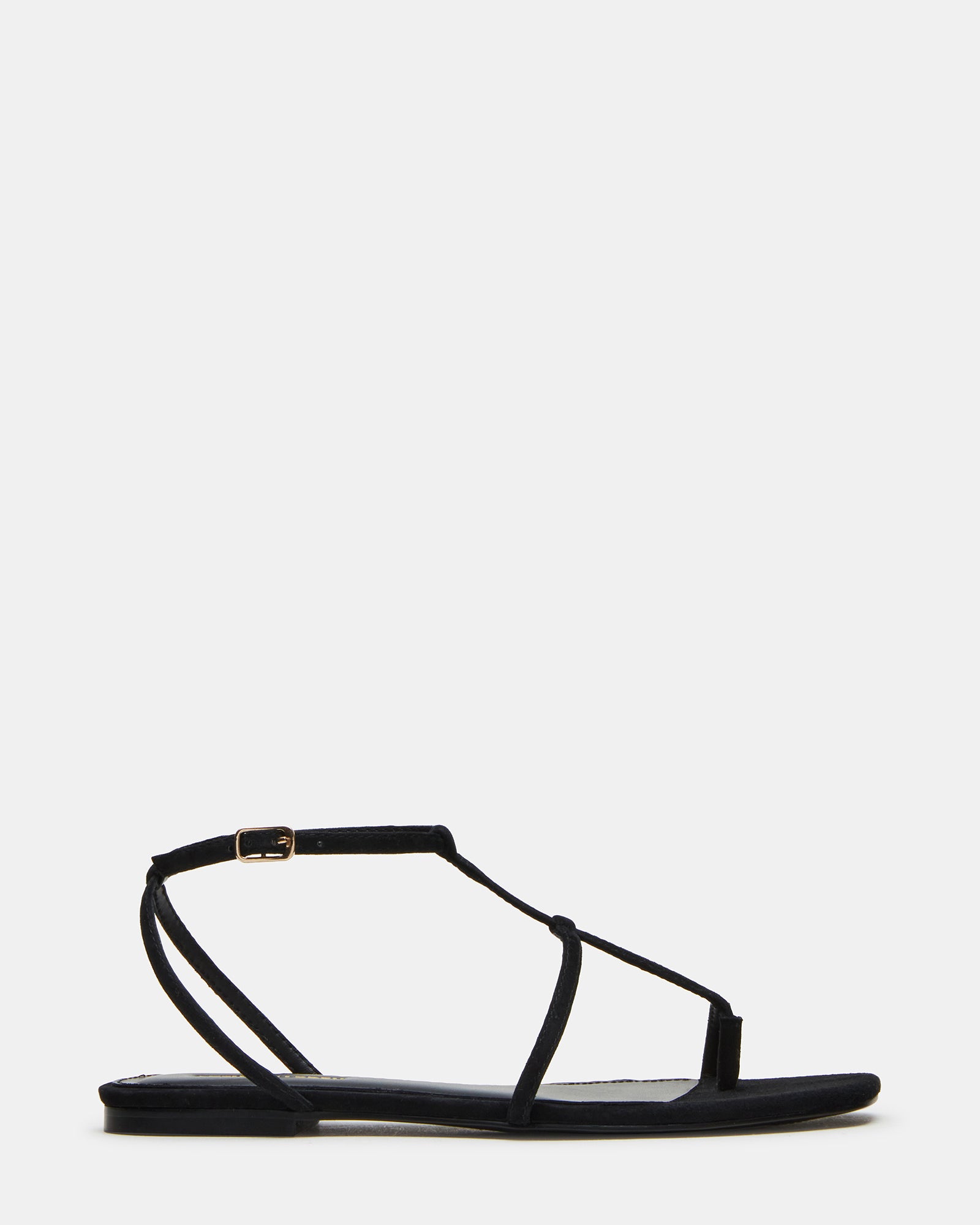 Side view of black suede sandals with flat sole and strappy design on model