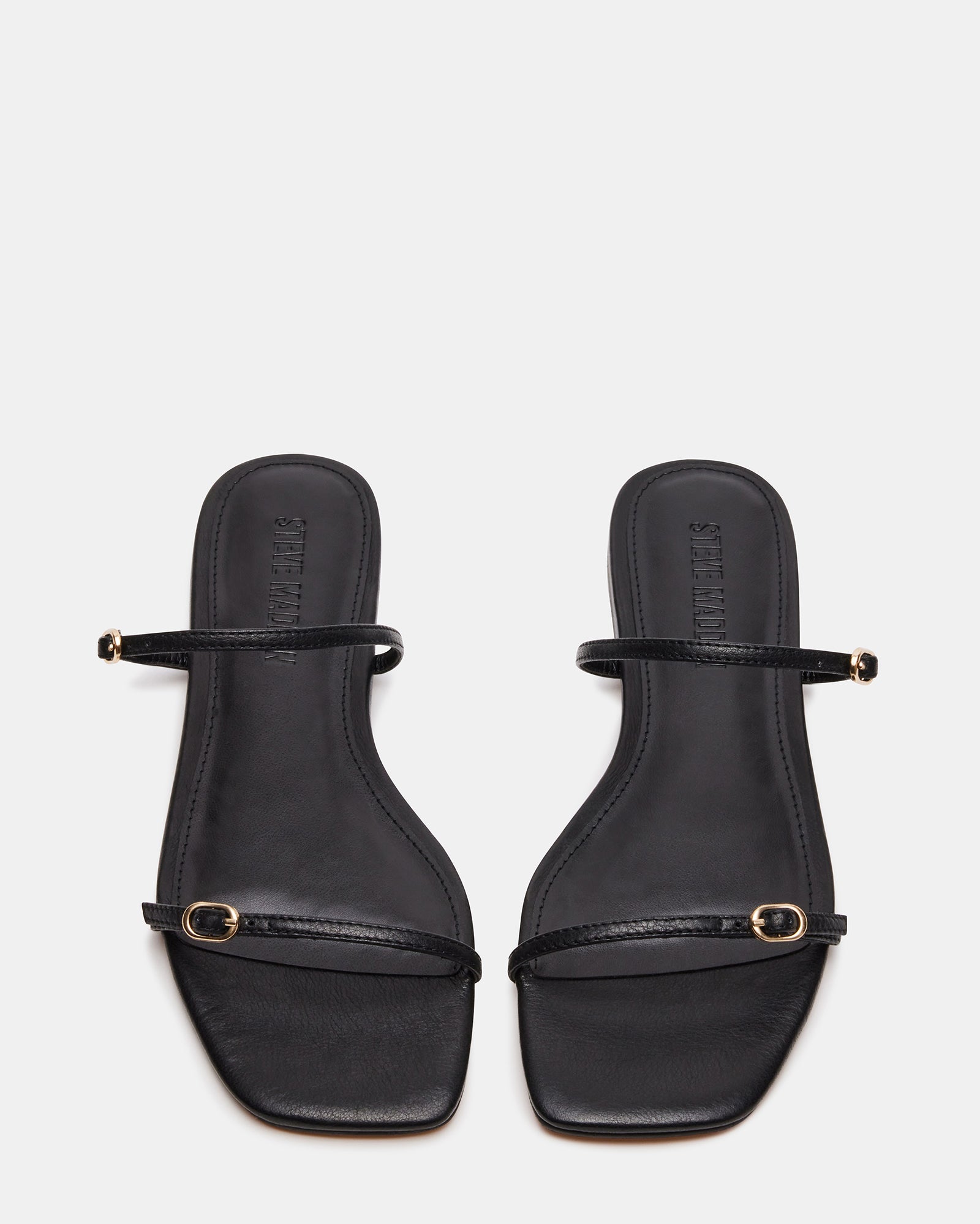 Side angle showing black leather sandals with thin straps and square toe