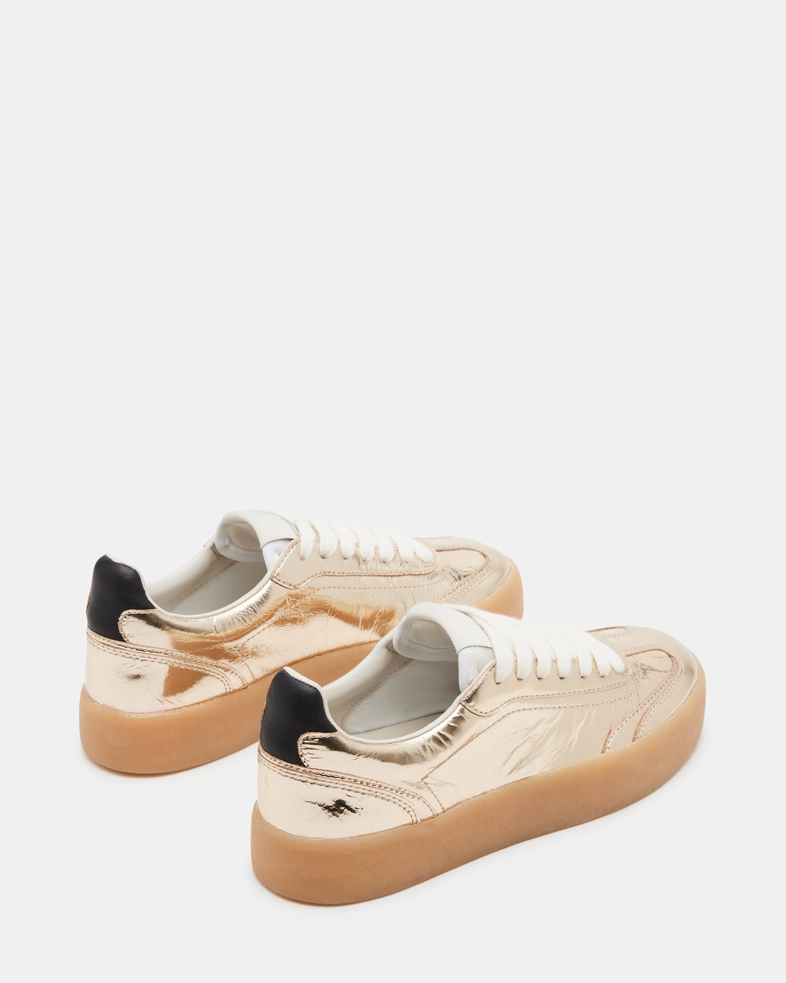 TUX Gold sneakers styled with casual jeans, perfect for urban outings