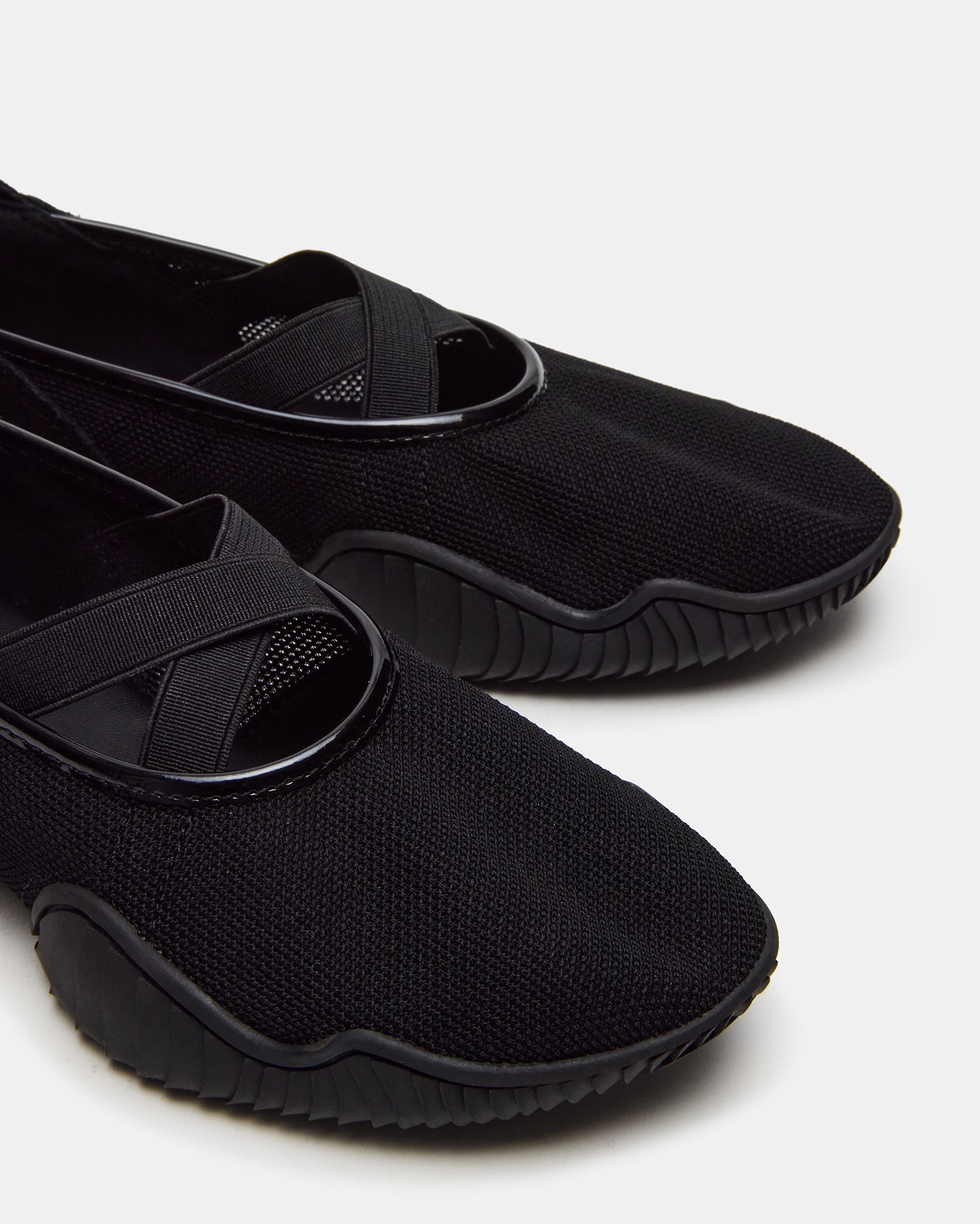 Pair of fashionable sneakers for guys and girls sitting beside travel bag