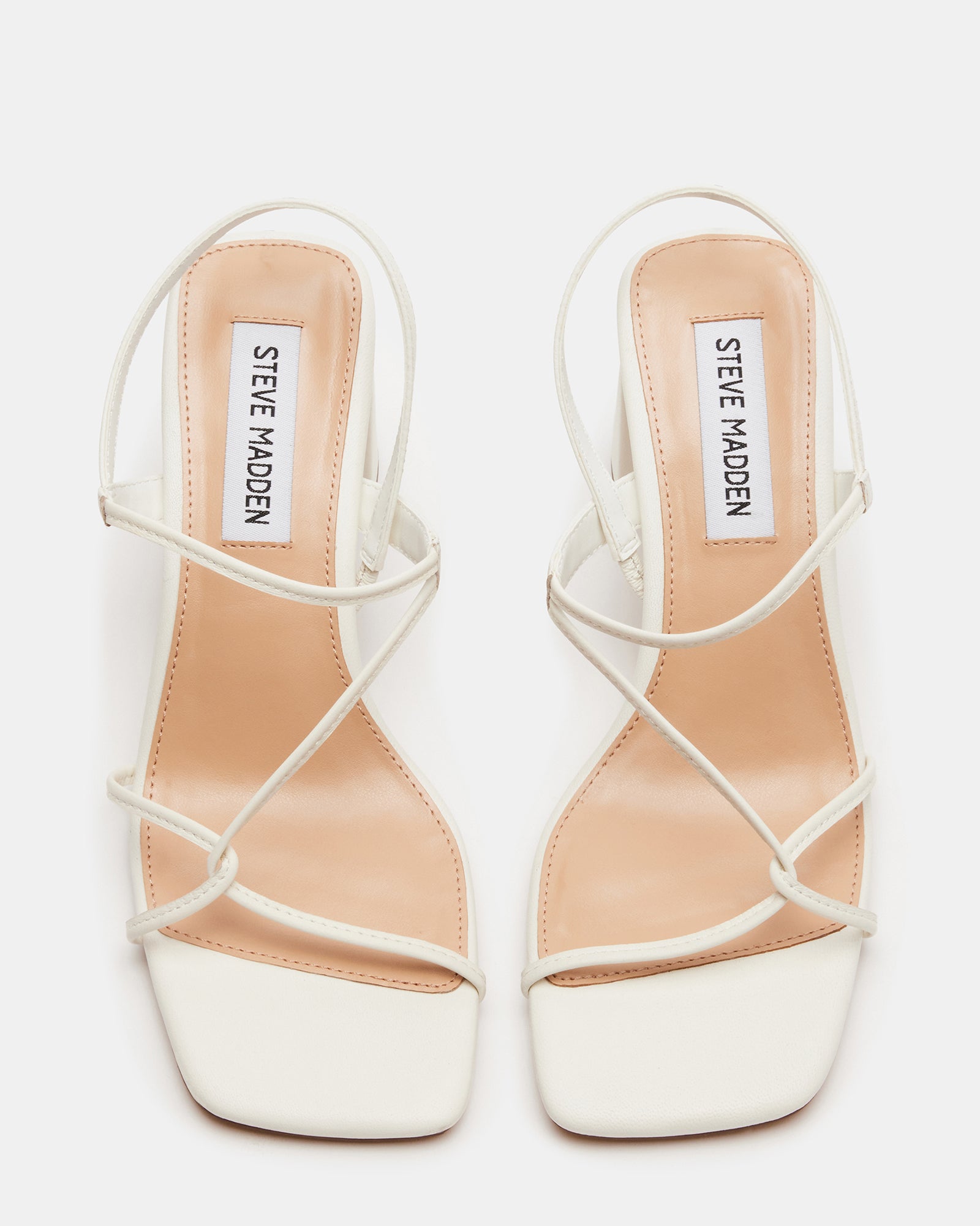 Valora white heels for women styled with a dress.