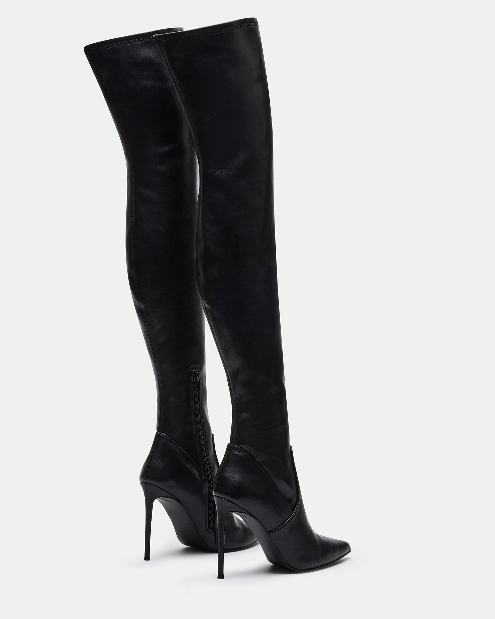 Model wearing knee-high boots in black vegan patent, ideal for NYC nightlife.