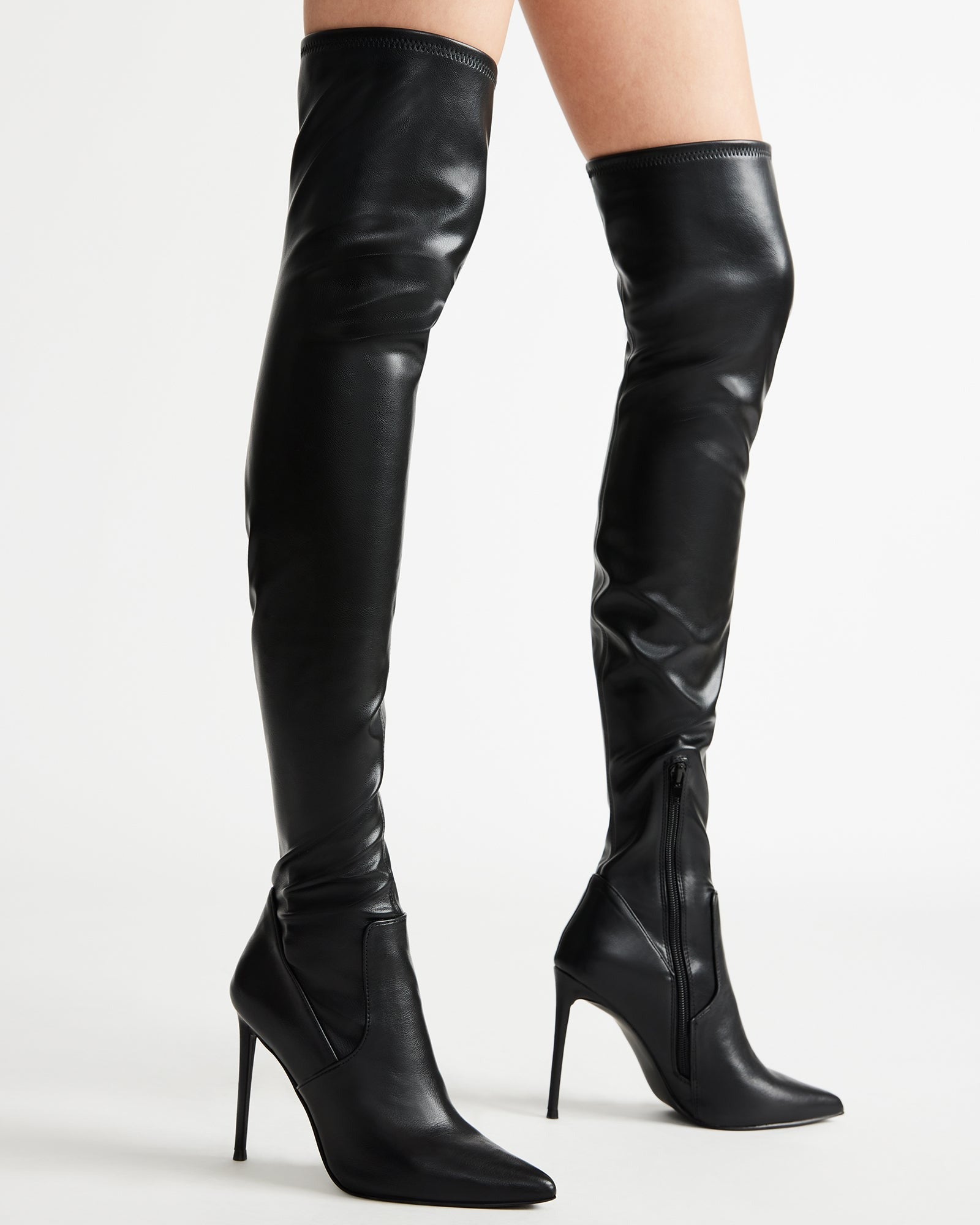 Close-up of vegan leather boots with reinforced top strap against a concrete backdrop.