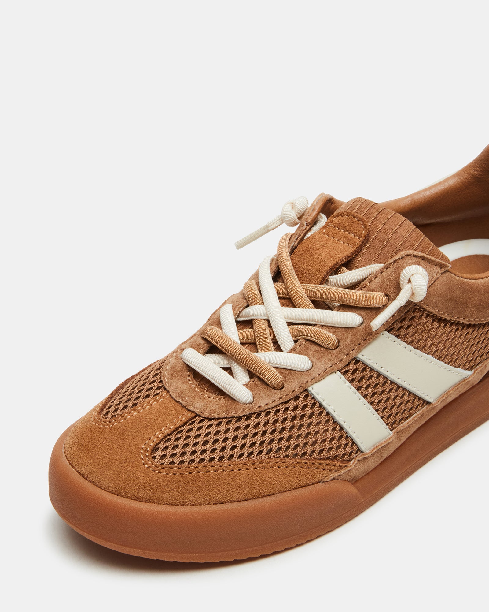 Side view of tan multi lace-up sneakers, styled for NYC streetwear