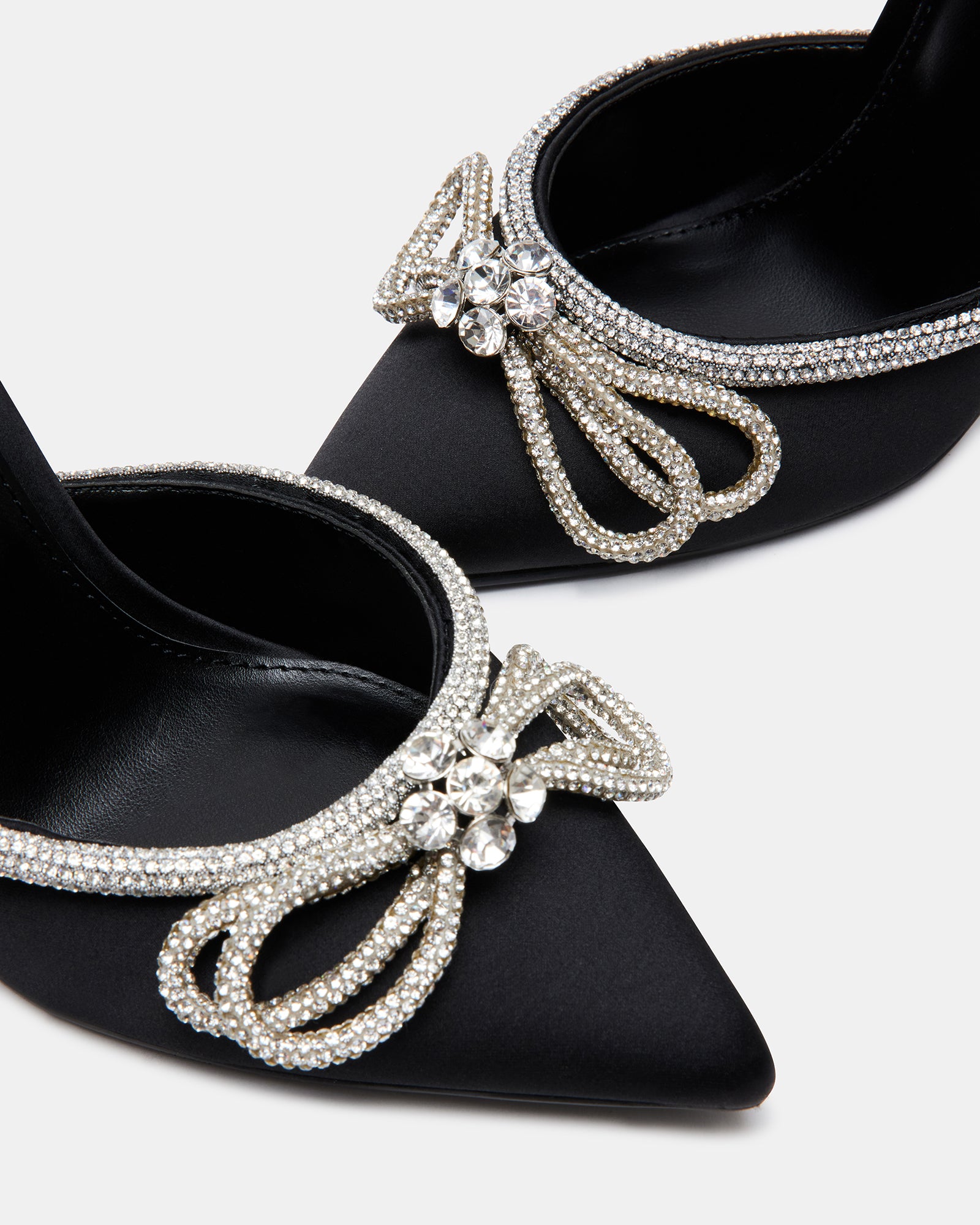 Close-up of pointed toe and bow detail – black heels styled for evening elegance.