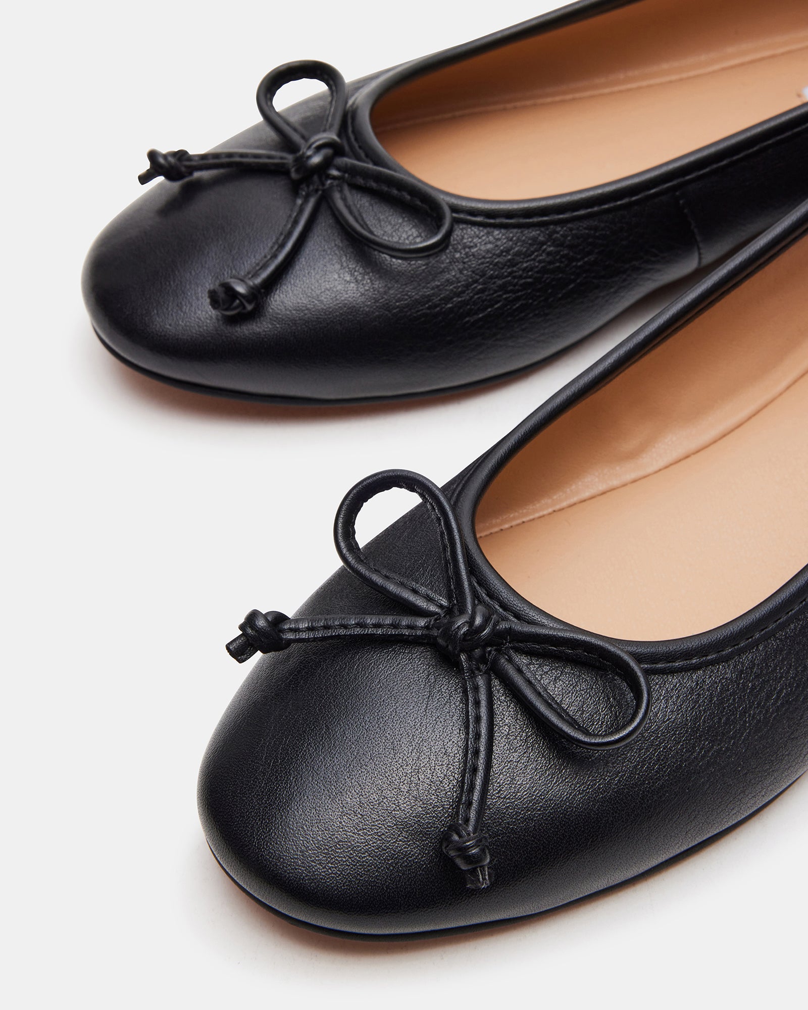 Black ballet flats styled with jeans for a casual look.