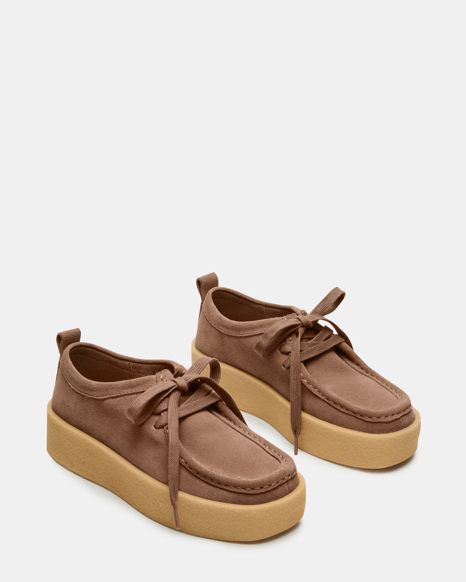 Close-up of taupe shoes with striped laces and textured suede surface