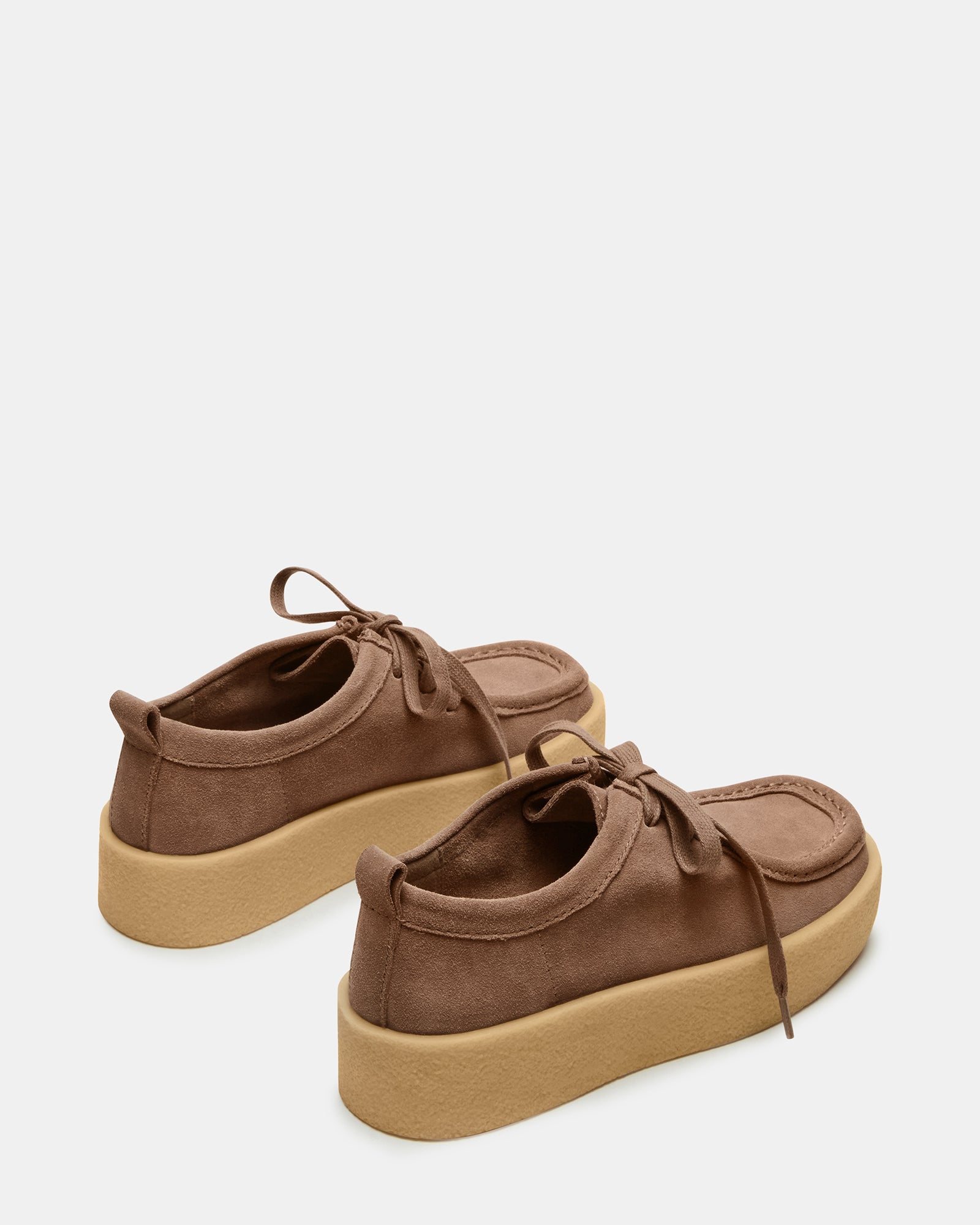 Close-up of taupe shoes with striped laces and textured suede surface