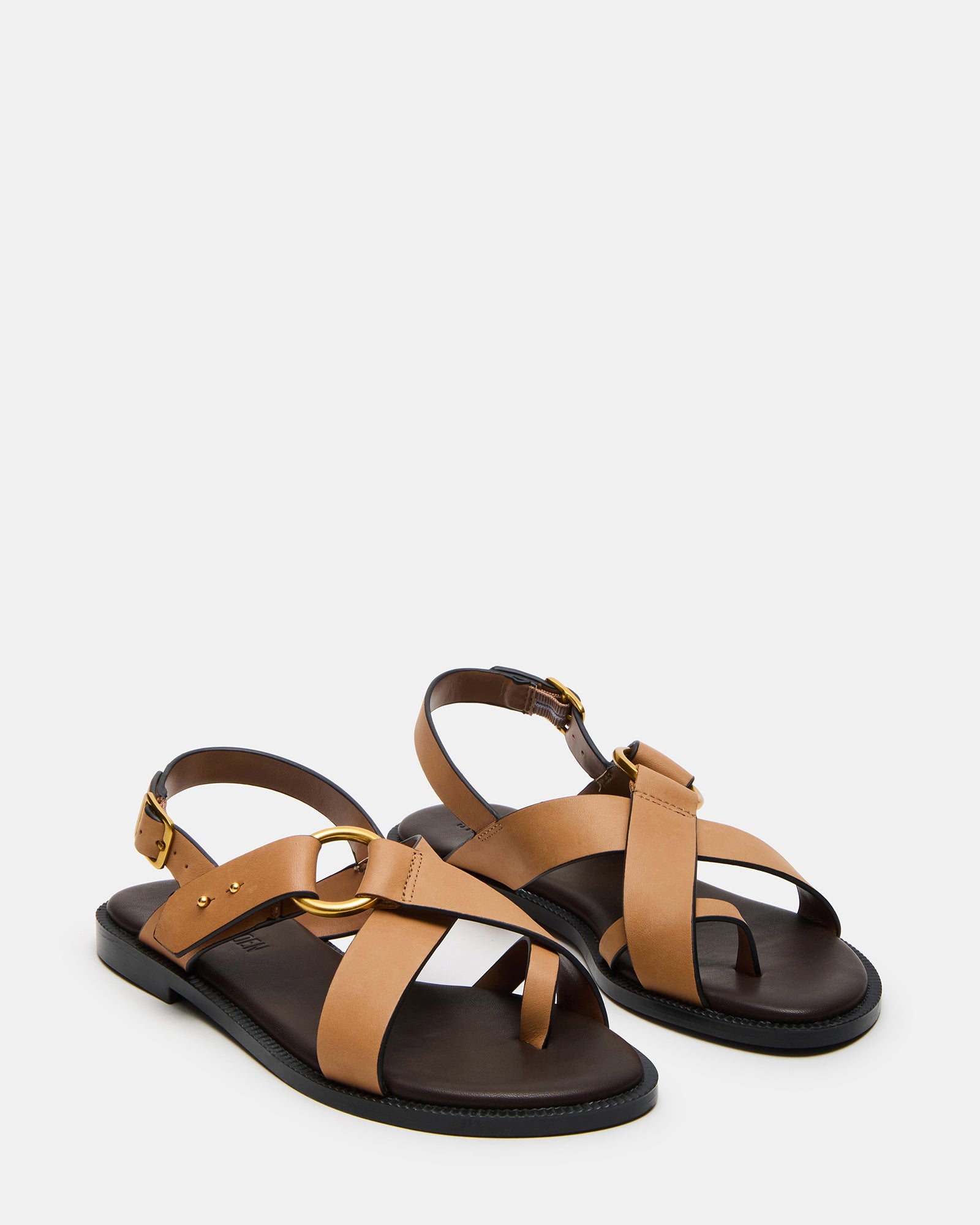 Model walking in tan leather flat sandals during summer day