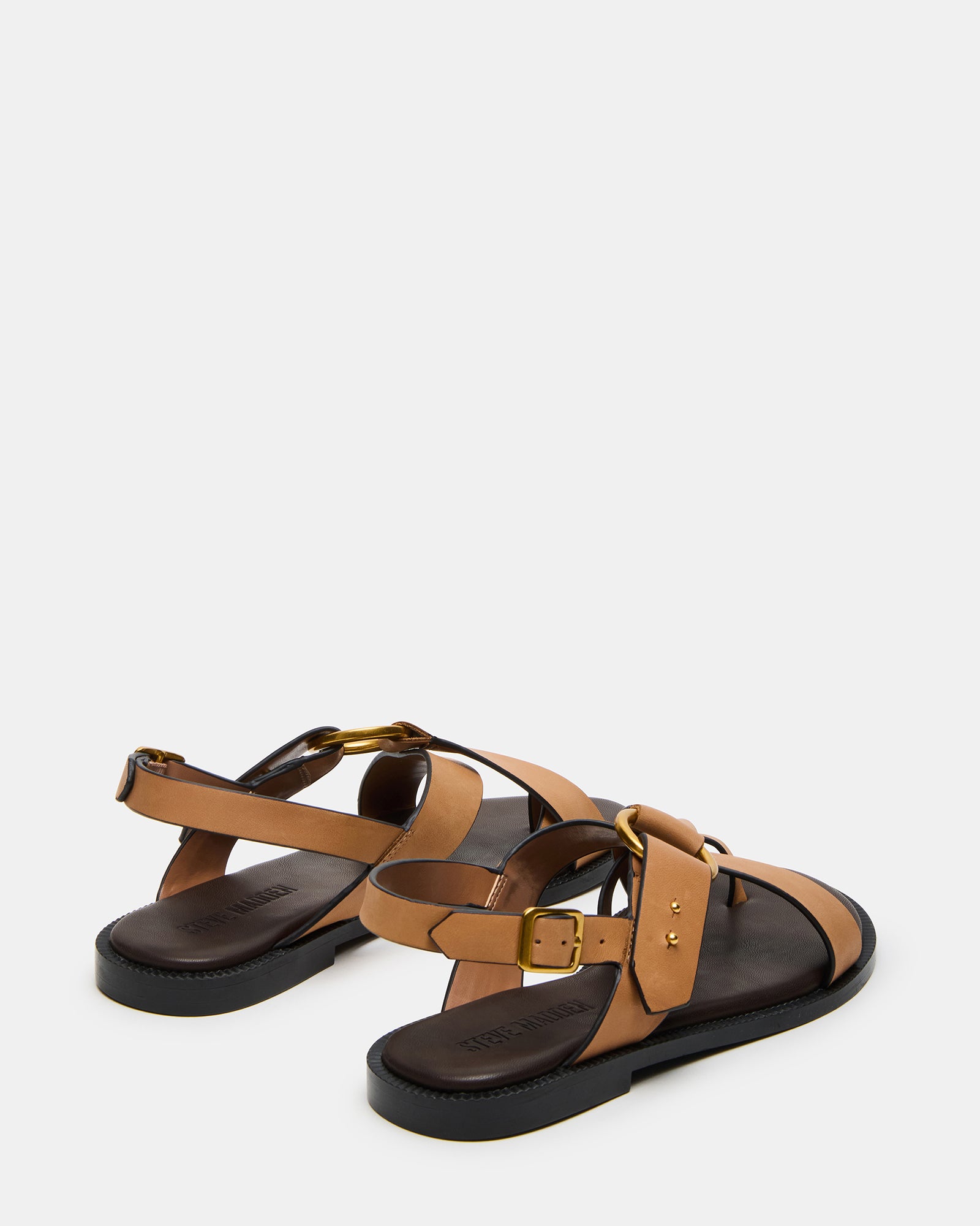 Model walking in tan leather flat sandals during summer day