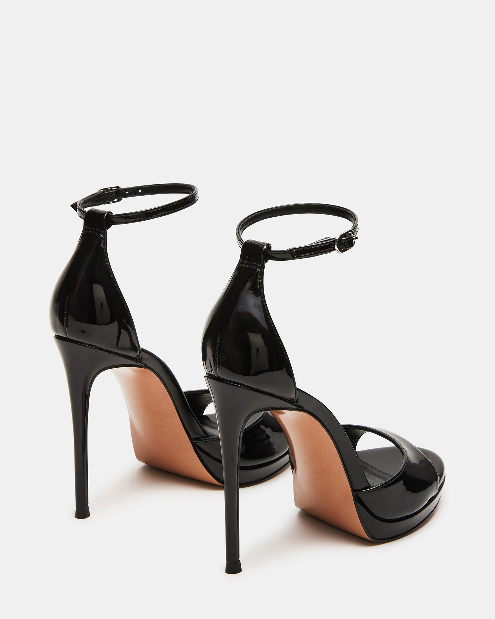 Woman wearing black strap around ankle heels at an event
