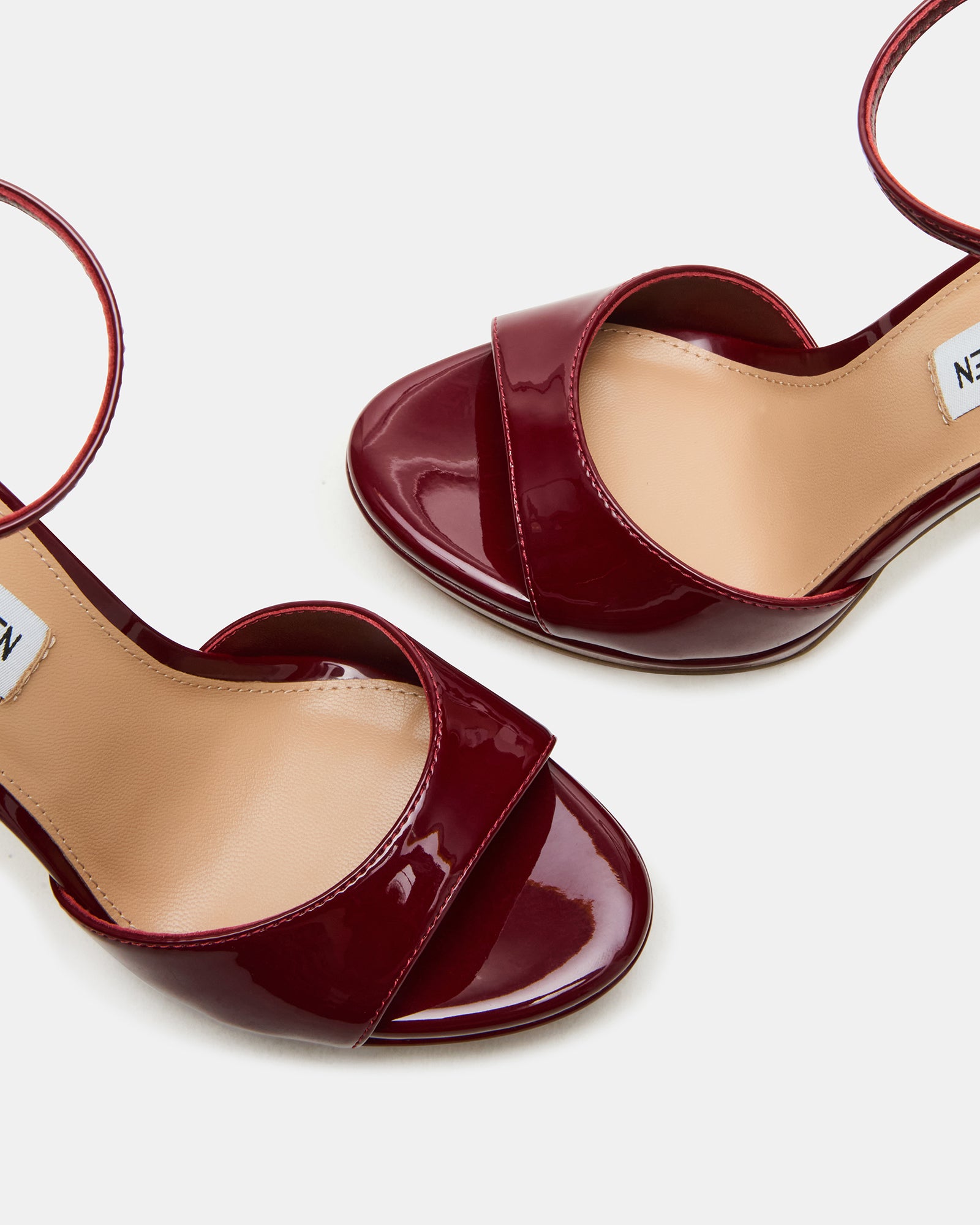 Side view of black patent leather shoes with ankle straps, perfect for formal events.