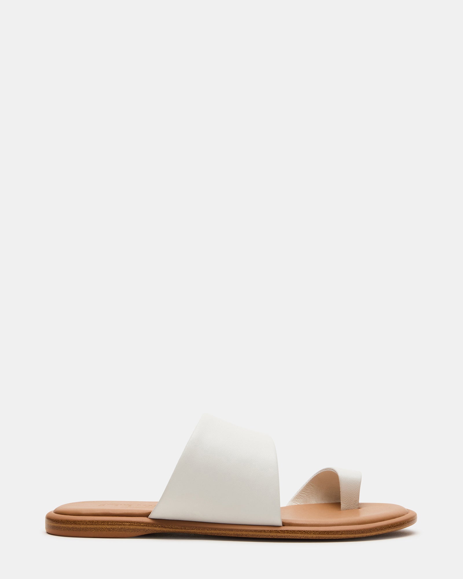 Top view of white leather sandals women's flat slides on wooden deck