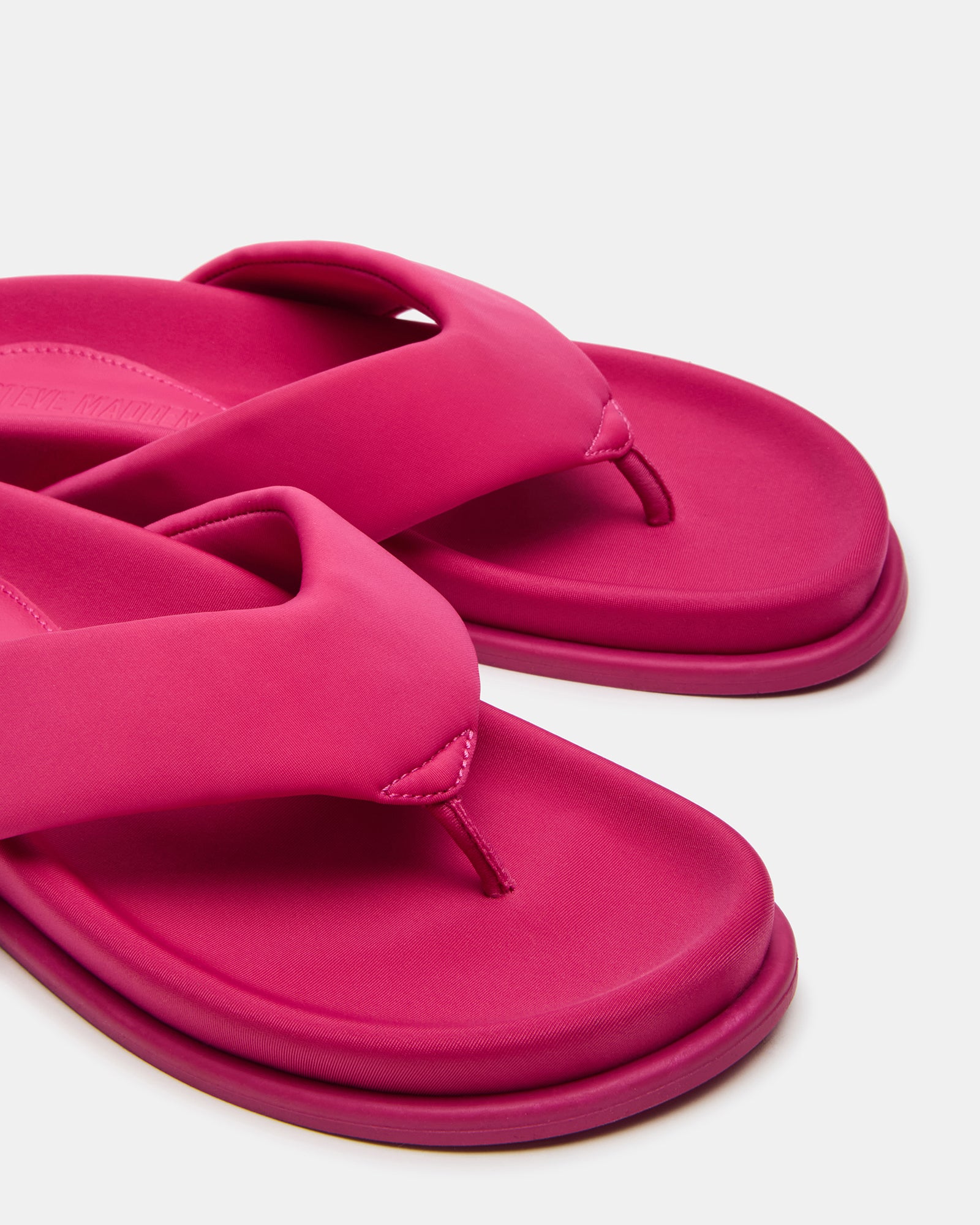Lifestyle shot of black thong sandals worn with summer outfit near poolside