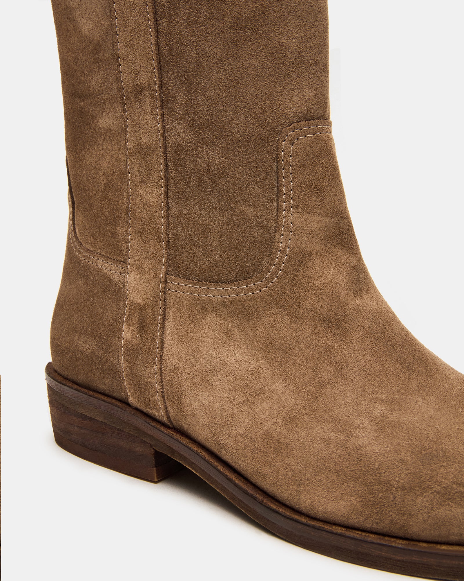 Front angle of suede knee-high boots, styled with jeans