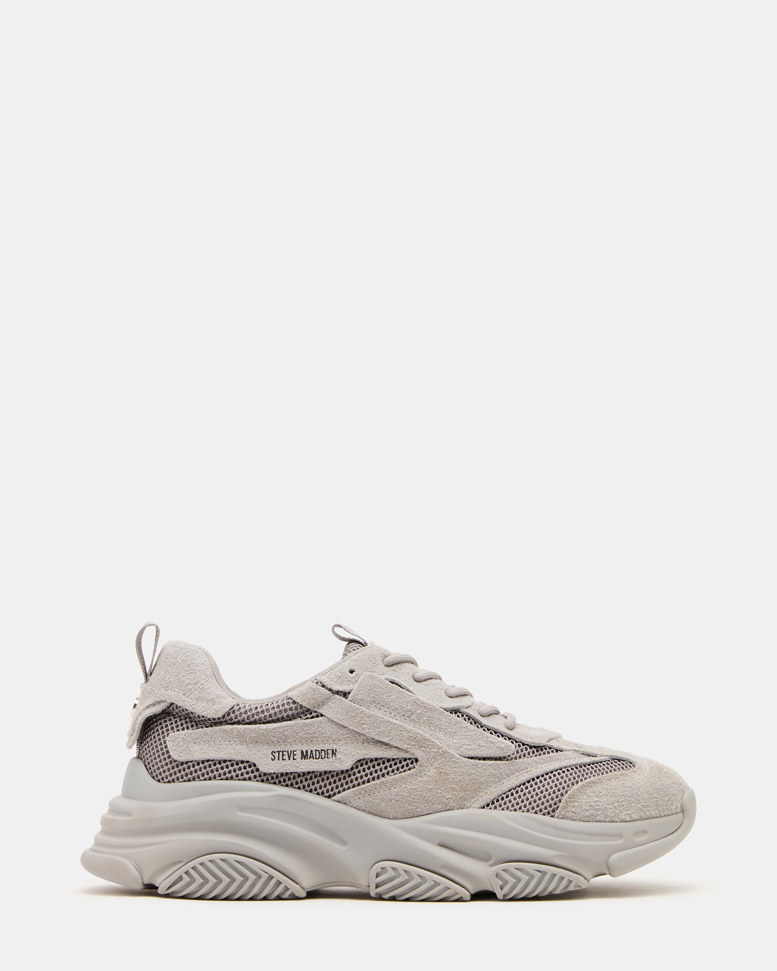 Side view of grey suede chunky platform sneakers on a city street.