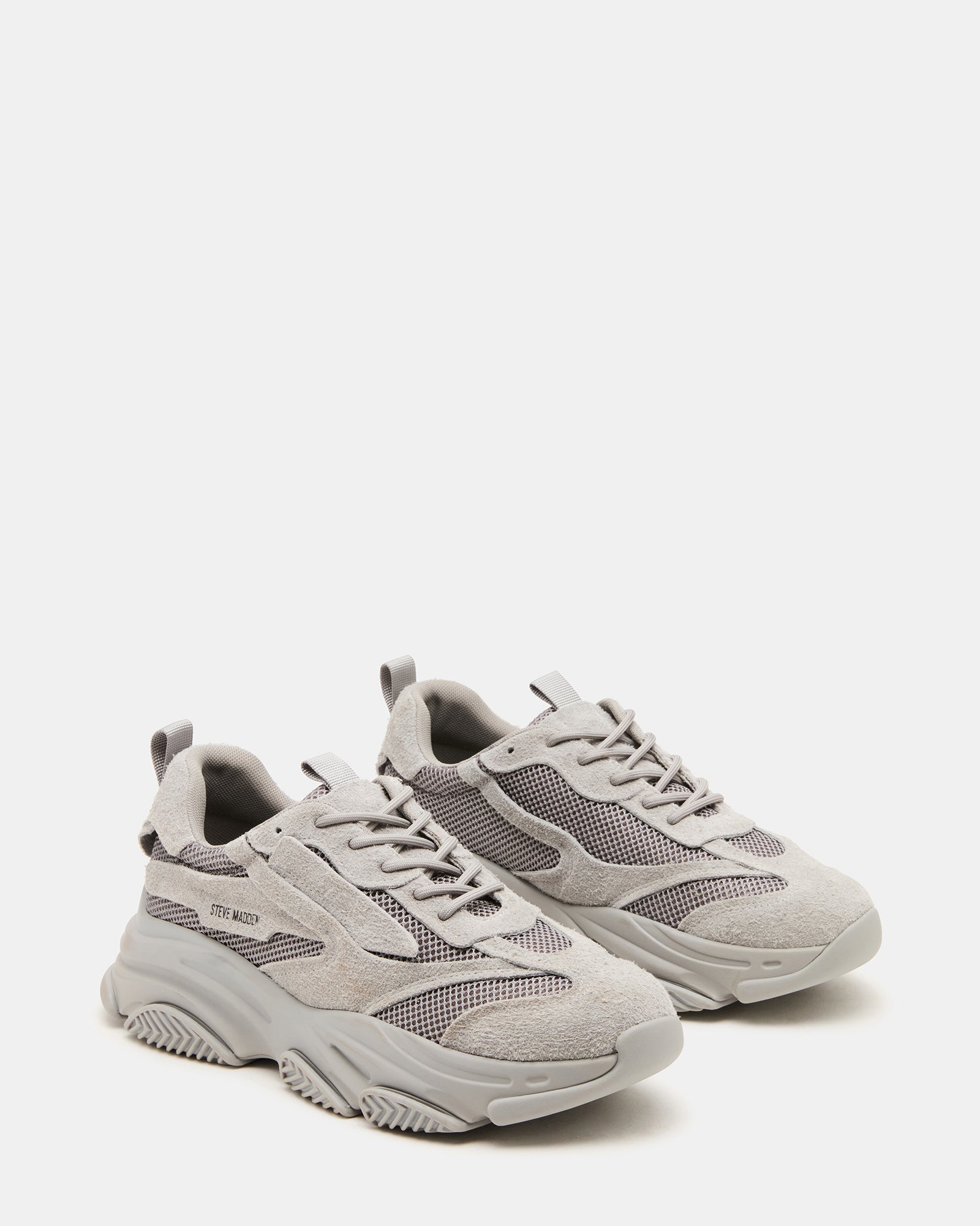 Person wearing grey chunky platform sneakers, showcasing versatility.