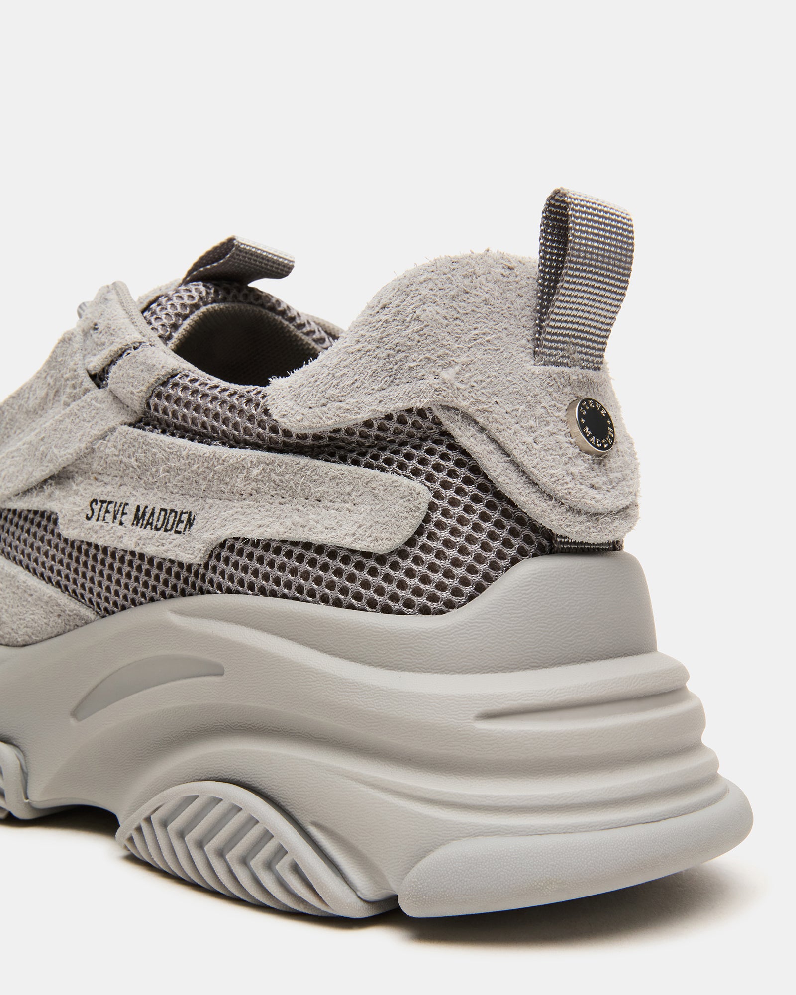 Side view of grey suede chunky platform sneakers on a city street.