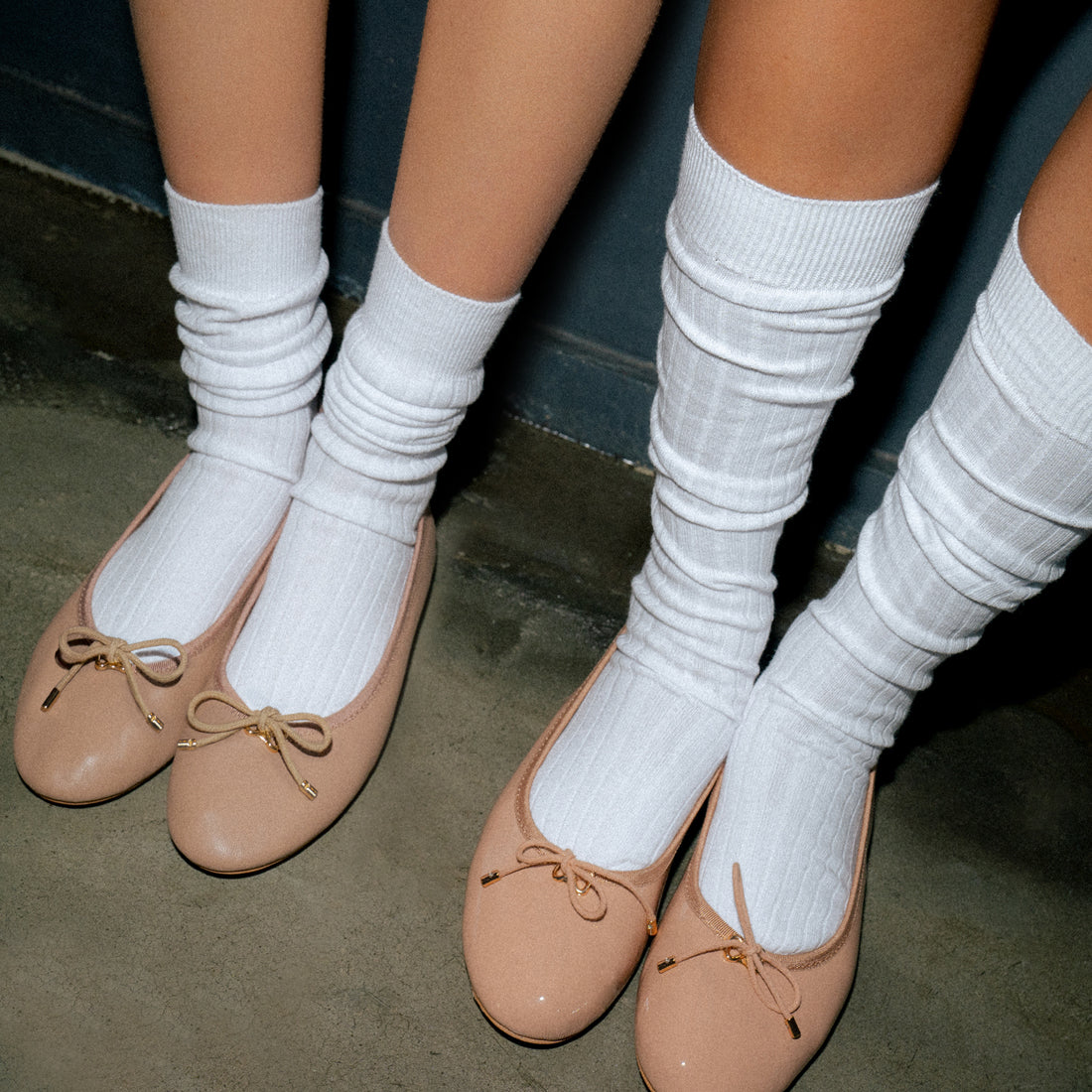 Model wearing knee high socks in white, showcasing their length and ribbed design